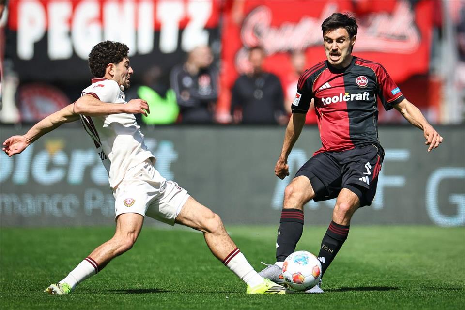 Tom Baack (r, 1. FC Nürnberg) und Ben Bobzien (Dynamo Dresden) kämpfen um den Ball.Daniel Karmann/dpa
