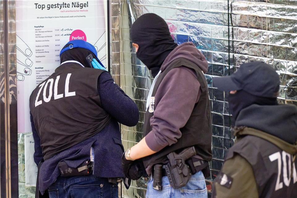 „Top gestylte Nägel“ steht auf einem Preisschild vor einem der durchsuchten Nagelstudios. Henning Kaiser/dpa