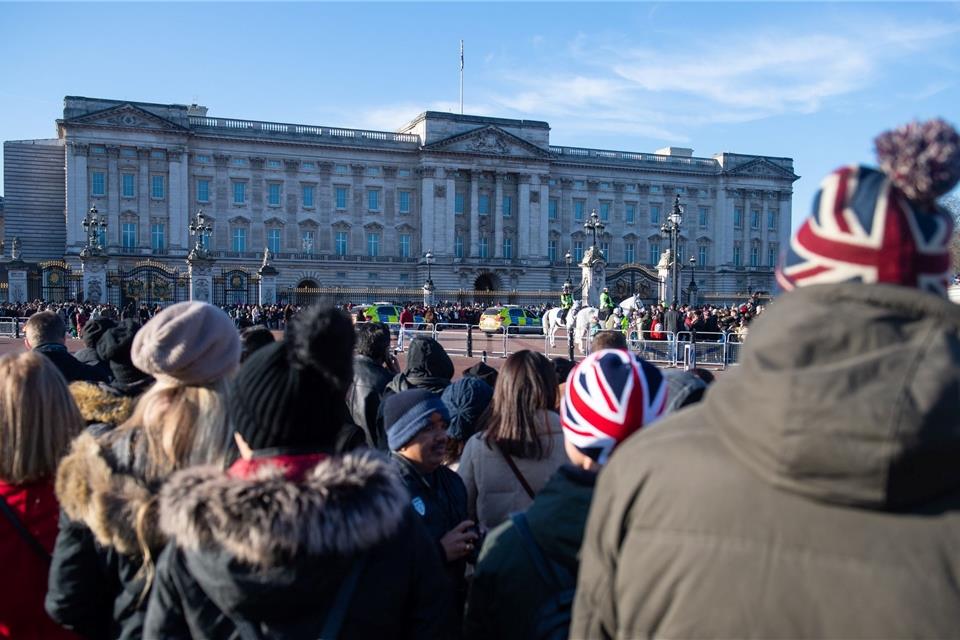 Touristen beobachten die Wachablösung vor dem Buckingham-Palast. Einer Umfrage zufolge sind 2022 bis Ende des Sommers 83 Prozent weniger Schülerinnen und Schüler aus Europa nach Großbritannien gereist als noch 2019.