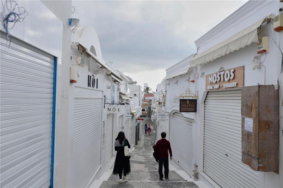 Erdbeben auf Santorini: Kontakt mit Reiseanbieter halten Touristen gehen an geschlossenen Geschäften in der Stadt Fira vorbei. Die griechischen Behörden ergreifen Notfallmaßnahmen als Reaktion auf die starken seismischen Aktivitäten auf der beliebten Ägäis-Ferieninsel Santorini in Südgriechenland.picture alliance/dpa/AP