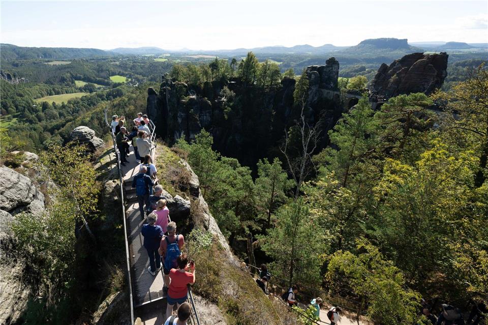 Touristen genießen die Felsenlandschaft der Sächsischen Schweiz. Die Tourismusbranche spricht von einer insgesamt guten Buchungslage in der aktuellen Sommersaison. (Archivbild)Sebastian Kahnert/dpa