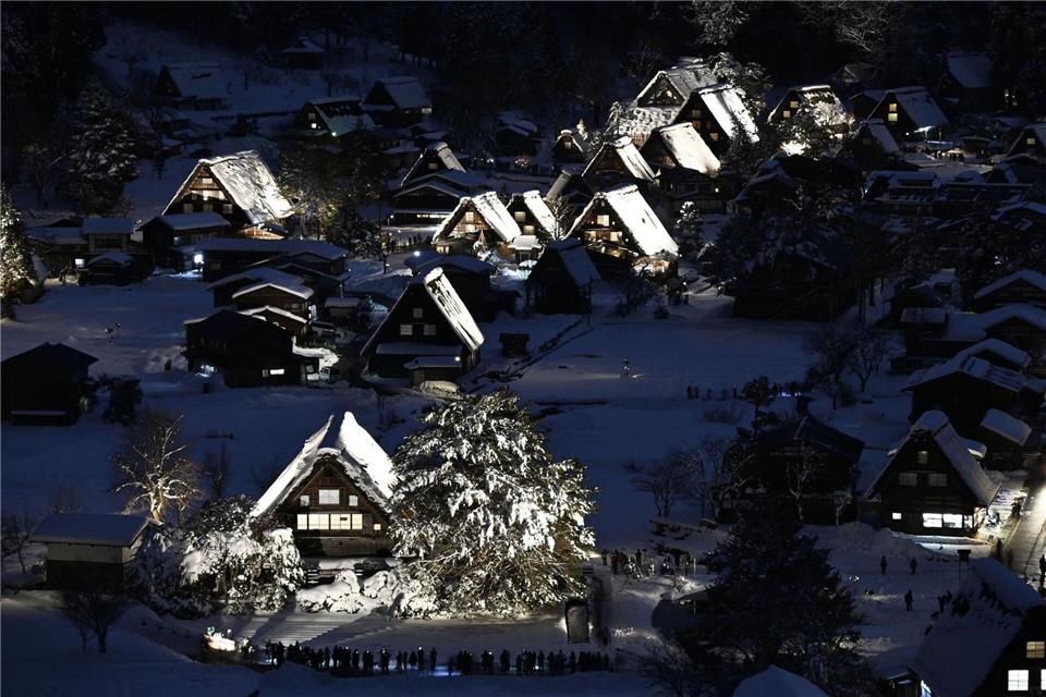 Traditionelle Strohdachhäuser sind mit Schnee bedeckt und werden im zum Weltkulturerbe gehörenden Dorf Shirakawa-go in der Präfektur Gifu in Zentraljapan beleuchtet.Uncredited/kyodo/dpa