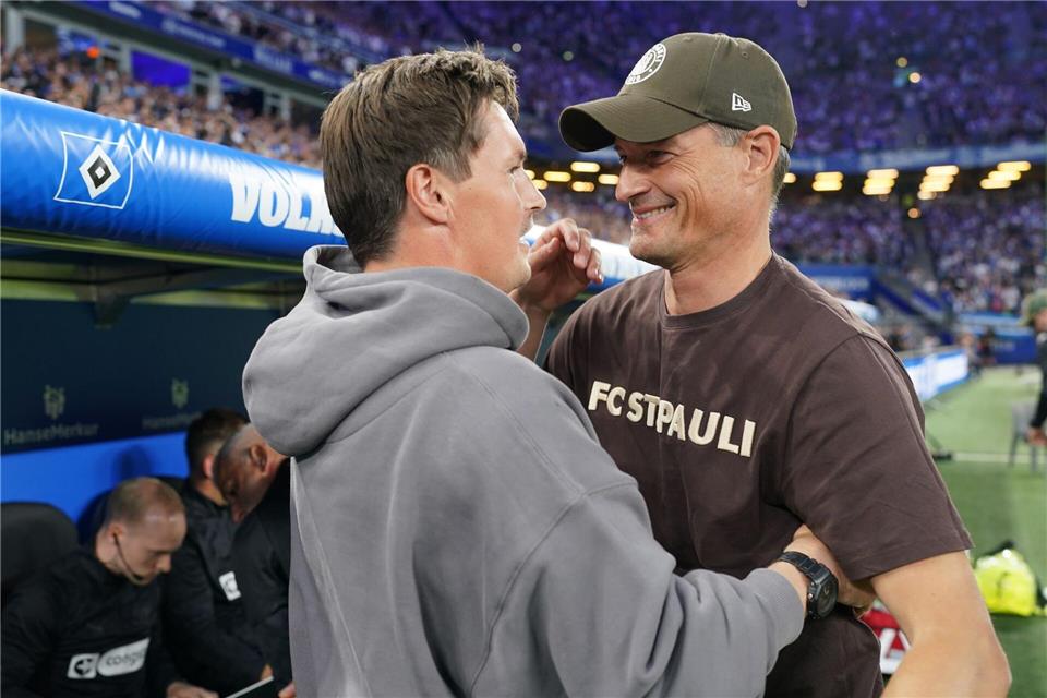 Trainer Alexander Blessin (r, FC St. Pauli) und Trainer Merlin Polzin (Hamburger SV) begrüßen sich vor dem Derby in der Hinrunde. (Archivbild)Marcus Brandt/dpa