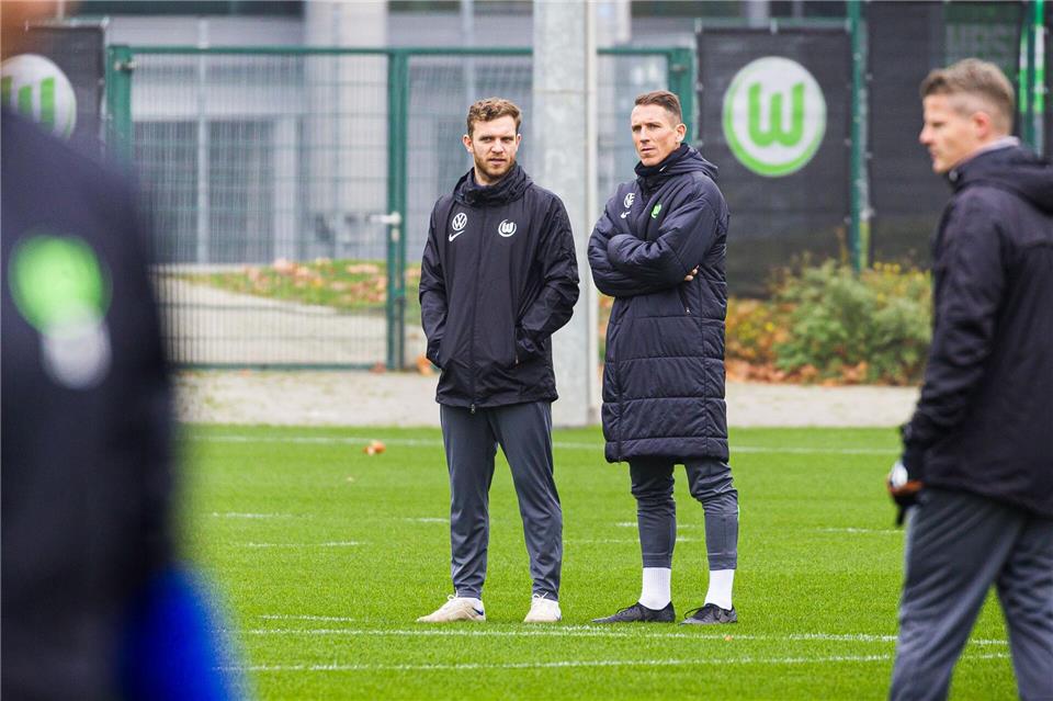 Trainer Daniel Bauer (2.v.l.) steht beim Training neben Co-Trainer Tobias Holm (l).Moritz Frankenberg/dpa