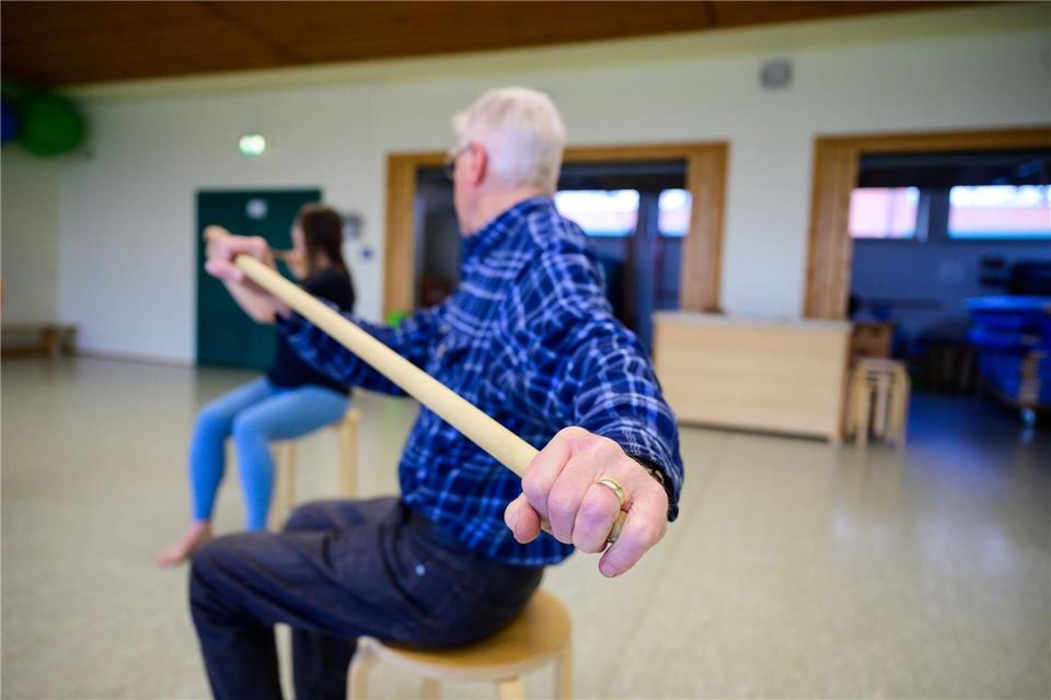 Trainiert werden unter anderem das Aufstehen vom Stuhl ohne Armunterstützung, der Stand auf einem Bein oder die Oberkörper-Flexibilität mit Stäben im Sitzen.Philipp Schulze/dpa