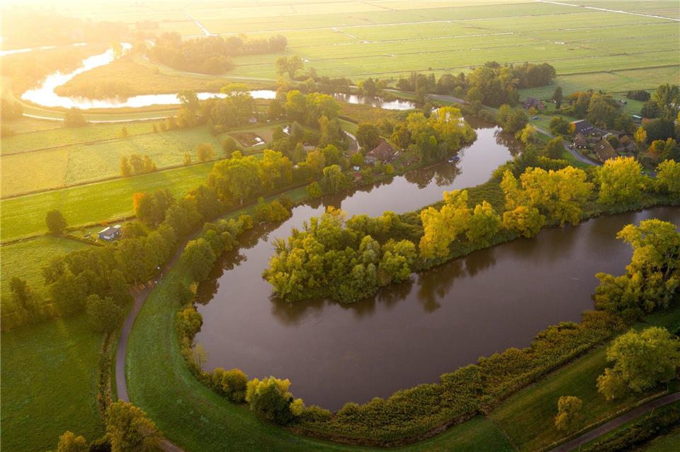 Bilder des Tages Traumlandschaft: Die Wümme fließt im Bremer Blockland vorbei an Bäumen, die bereits Herbstfarben tragen. Sina Schuldt/dpa
