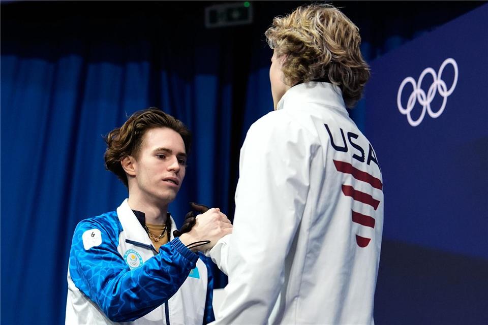 Trotz der großen Enttäuschung gratulierte Ilia Malinin (r) dem Olympiasieger Michail Schaidorow fair.Ashley Landis/AP/dpa