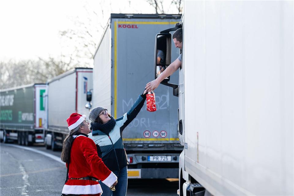 Trucker freuen sich über ein kleines Geschenk.Silas Stein/dpa