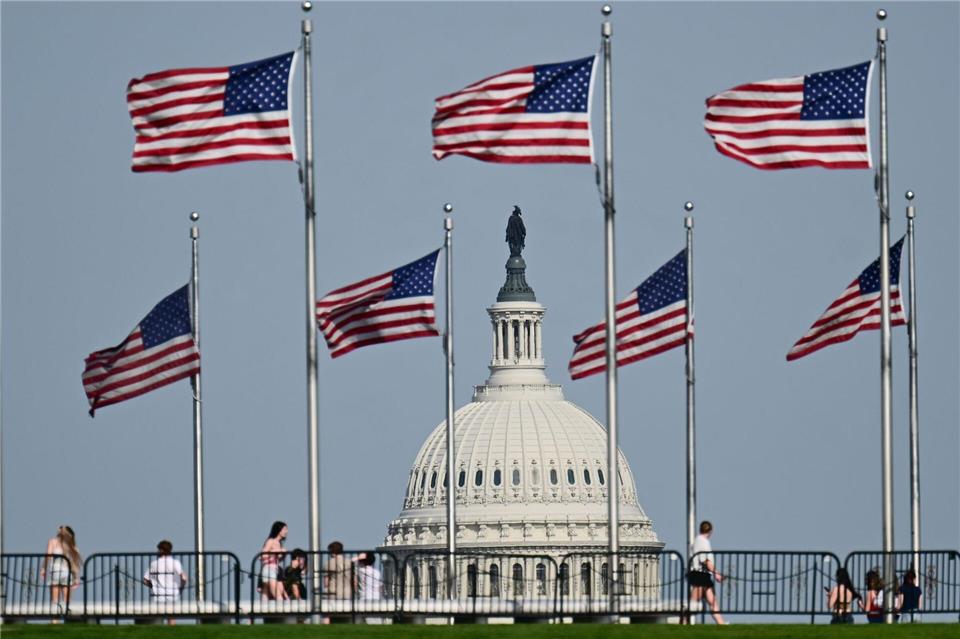 US-Fahnen wegen am Washington Monument. Im Hintergrund ist die Kuppel des US-Kapitols zu sehen.Sebastian Christoph Gollnow/dpa