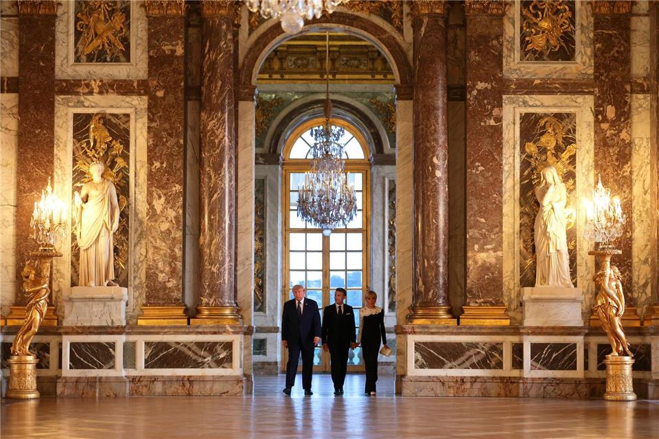 US-Präsident Donald Trump (l) wird vor einem gemeinsamen Abendessen vom französischen Präsidenten Emmanuel Macron und dessen Ehefrau Brigitte Macron durch das Schloss Versailles geführt. Anna Moneymaker/Pool Getty Images/AP/dpa