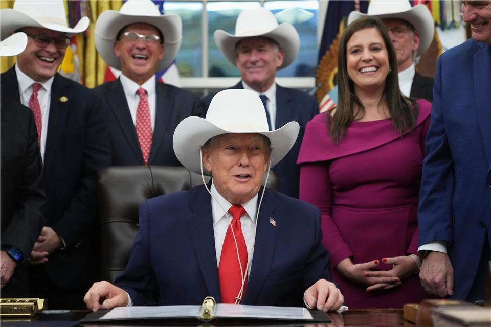 US-Präsident Donald Trump nimmt im Oval Office des Weißen Hauses in Washington an einer Zeremonie zur Unterzeichnung eines Gesetzentwurfs mit Mitgliedern des olympischen US-Eishockeyteams der Männer von 1980 teil und trägt einen Cowboyhut.Jacquelyn Martin/AP/dpa