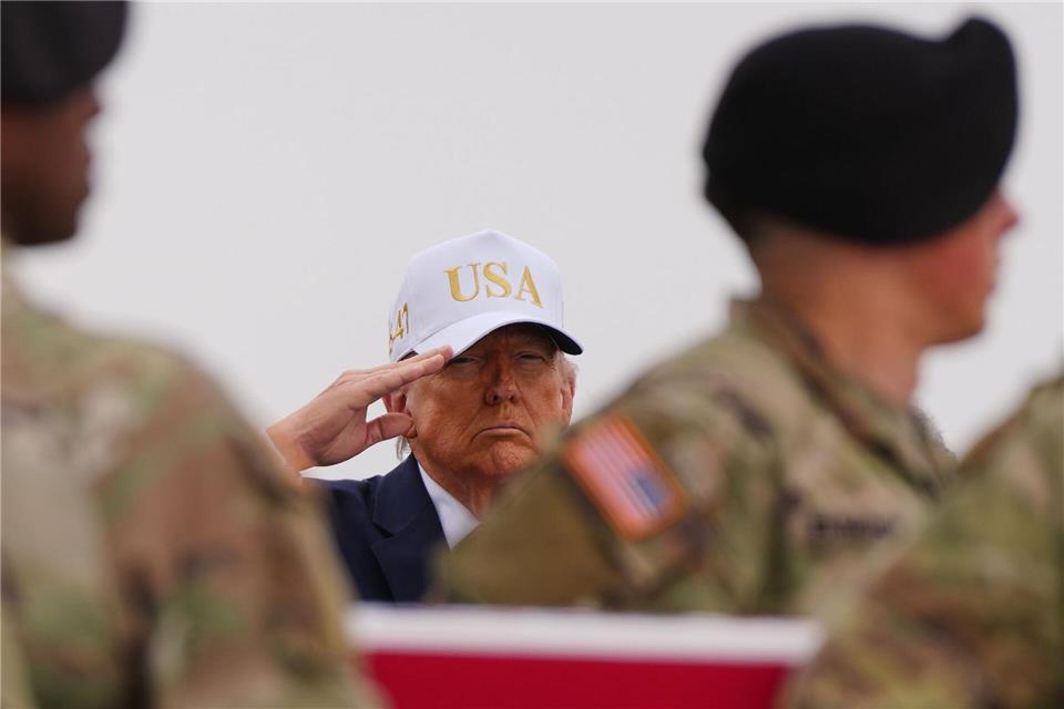 US-Präsident Donald Trump salutiert hinter einer mit der US-Flagge bedeckte Transportkiste mit den sterblichen Überresten eines US-Soldaten, der bei einem iranischen Drohnenangriff auf eine Kommandozentrale in Kuwait getötet wurde.Julia Demaree Nikhinson/AP/dpa