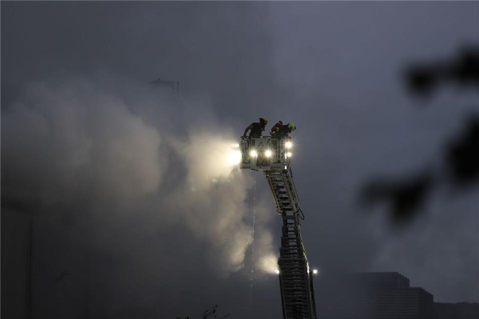 Massen an Sperrmüll geraten in Brand - Feuerwehr-Großeinsatz Über eine Drehleiter kämpfen Feuerwehrleute an der Sperrmüll-Halle gegen den Brand.Sascha Thelen/dpa