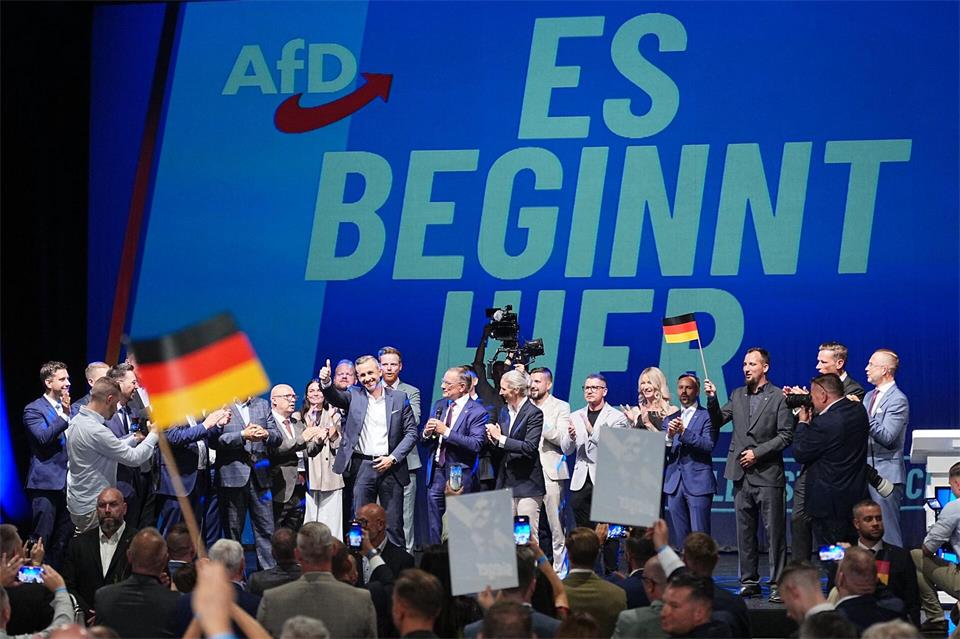 Ulrich Siegmund steht mit Funktionären der AfD bei der Wahlparty der AfD im Alten Theater in Magdeburg vor dem Schriftzug „Es beginnt hier“ auf der Bühne.Michael Kappeler/dpa