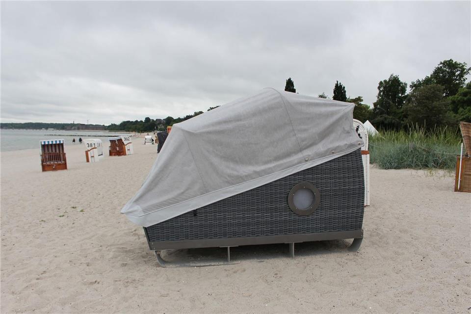 Um sich vor Wind, Regen und neugierigen Blicken zu schützen, kann man einfach das Verdeck des Schlafstrandkorbs schließen. Ricarda Dieckmann/dpa-tmn
