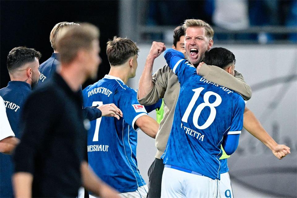 Ungewohnt emotional: Lilien-Trainer Florian Kohfeldt feiert mit seinen Spielern den ersten Saisonsieg.Uwe Anspach/dpa
