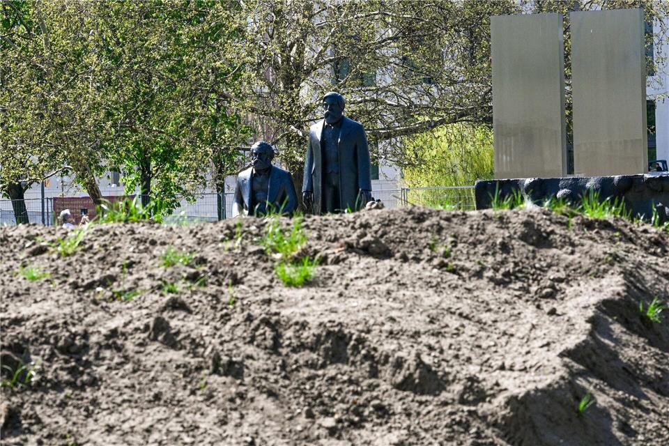 Ungewohnter Anblick: Vor den Bronzefiguren von Karl Marx und Friedrich Engels türmen sich Erdhaufen auf. Jens Kalaene/dpa