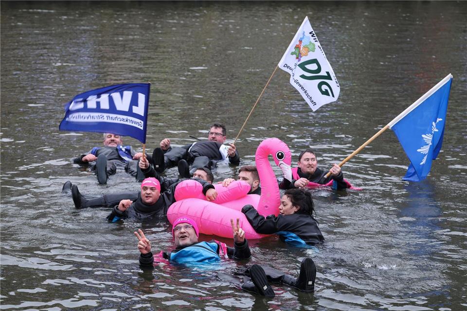 Unter dem Motto „Wir gehen baden, damit der Norden nicht absäuft“ schwimmen Teilnehmer beim Warnstreik im öffentlichen Dienst in Hamburg. Christian Charisius/dpa