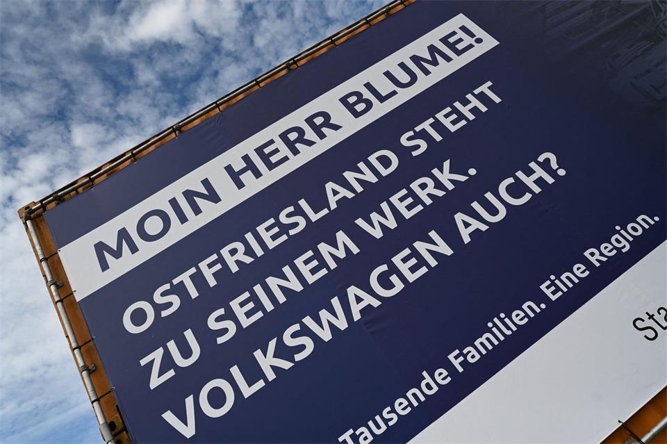 VW-Chef Blume wird in Emden mit einem Schriftzug und der Frage nach der Zukunft begrüßt. Lars Penning/dpa