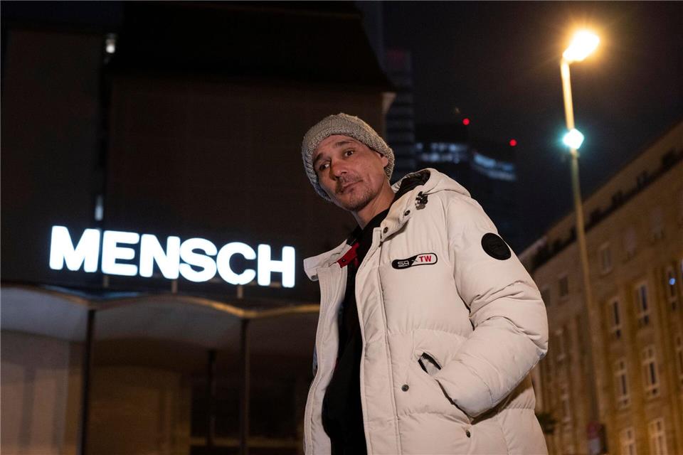 Valeri aus Bulgarien steht vor dem Schriftzug „Mensch“ auf dem Dach der Weißfrauenkirche im Bahnhofsviertel von Frankfurt. Boris Roessler/dpa