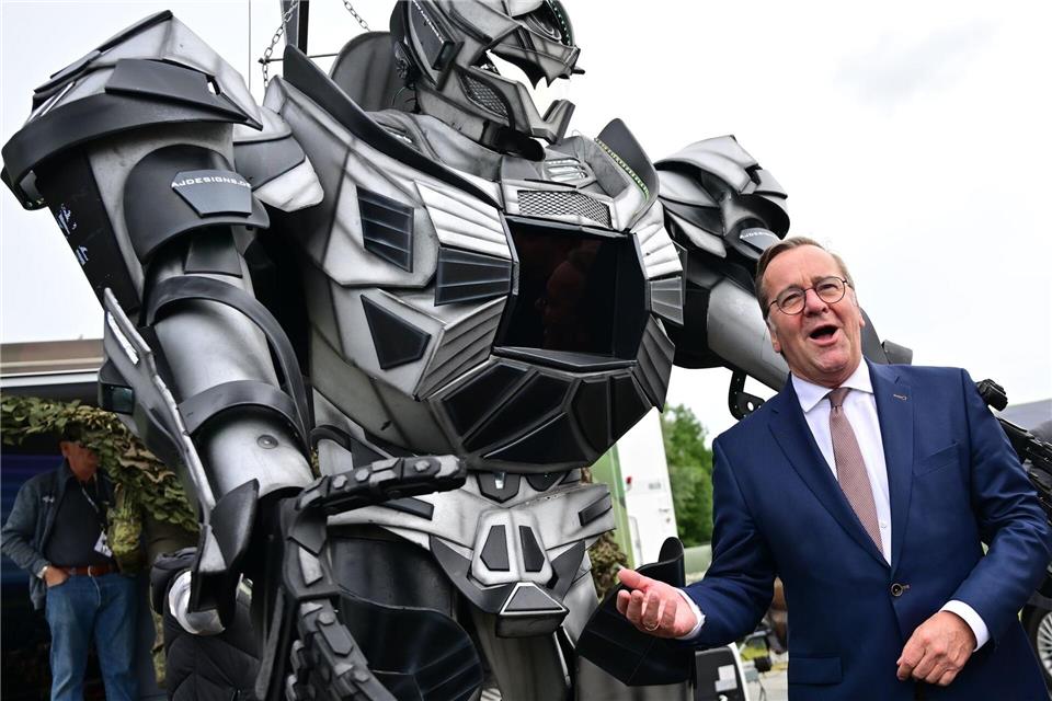 Verteidigungsminister Pistorius scherzt neben einer Transformer-Figur bei der ILA 2026 in Berlin.Sebastian Gollnow/dpa