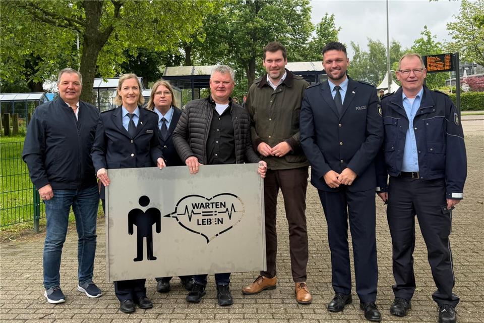 Vertreter der Kreispolizei, des Kreises Borken und der Stadt Ahaus mit der Schablone, mit der die Piktogramme aufgebracht werden sollen.