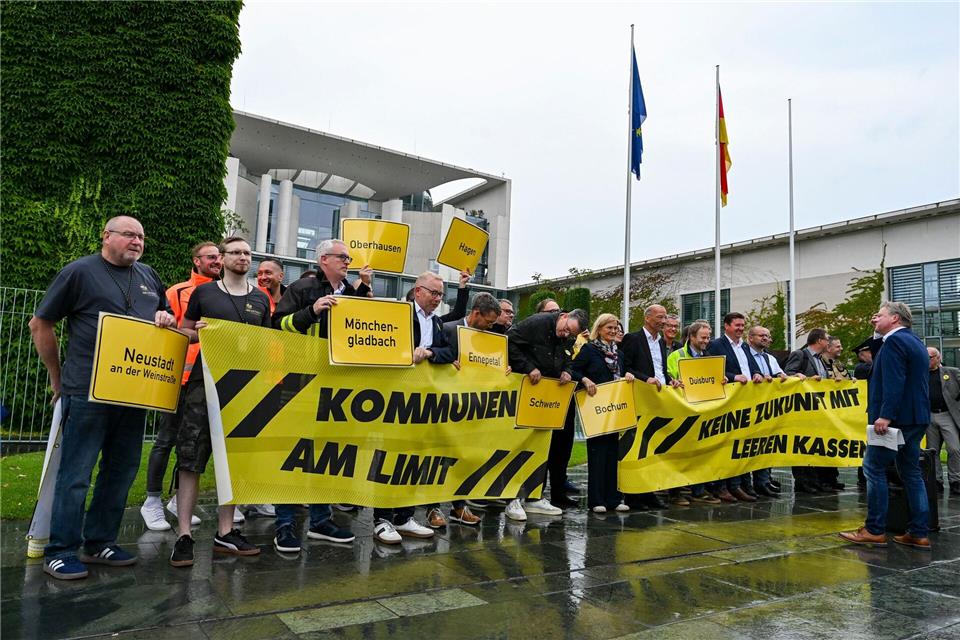 Vertreter mehrerer Städte und Kommunen demonstrieren mit Schildern und Bannern für finanzielle Unterstützung in Berlin.Jens Kalaene/dpa