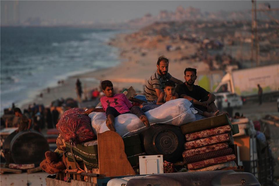 Vertriebene Palästinenser fliehen aus Gaza und tragen ihre Habseligkeiten entlang der Küstenstraße in Richtung des südlichen Gazastreifens.Abdel Kareem Hana/AP/dpa