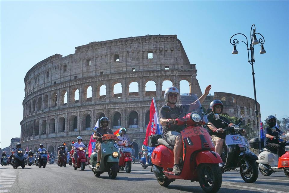 Vespa-Fans fahren am Kolosseum vorbei.Alessandra Tarantino/AP/dpa