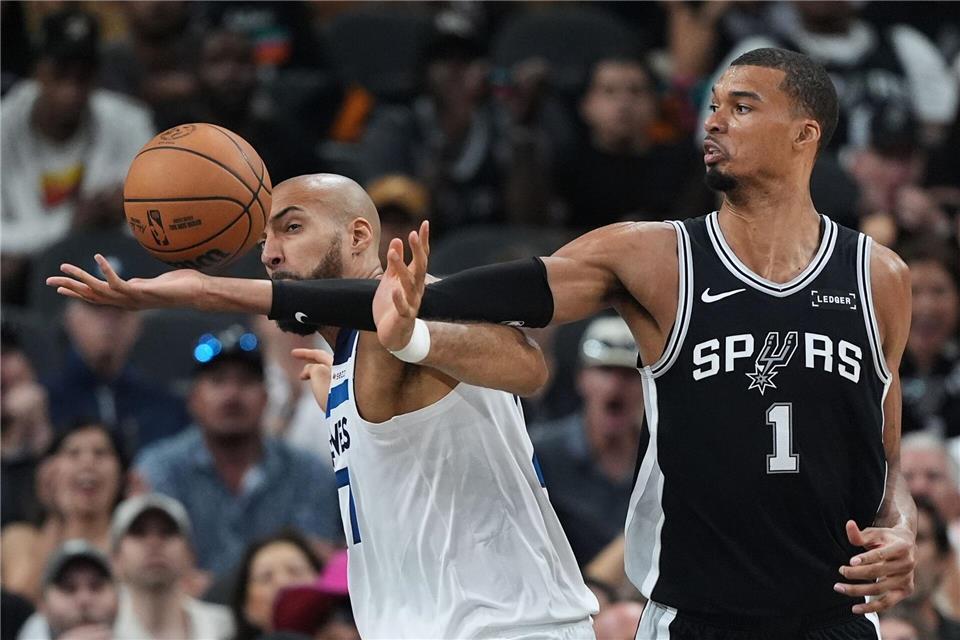 Victor Wembanyama (r) greift über Rudy Gobert (l) nach einem Rebound.Eric Gay/AP/dpa