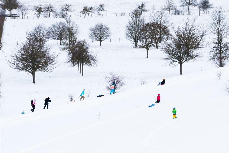 Viele Menschen freuen sich über ein schneereiches Wochenende. Julian Stratenschulte/dpa