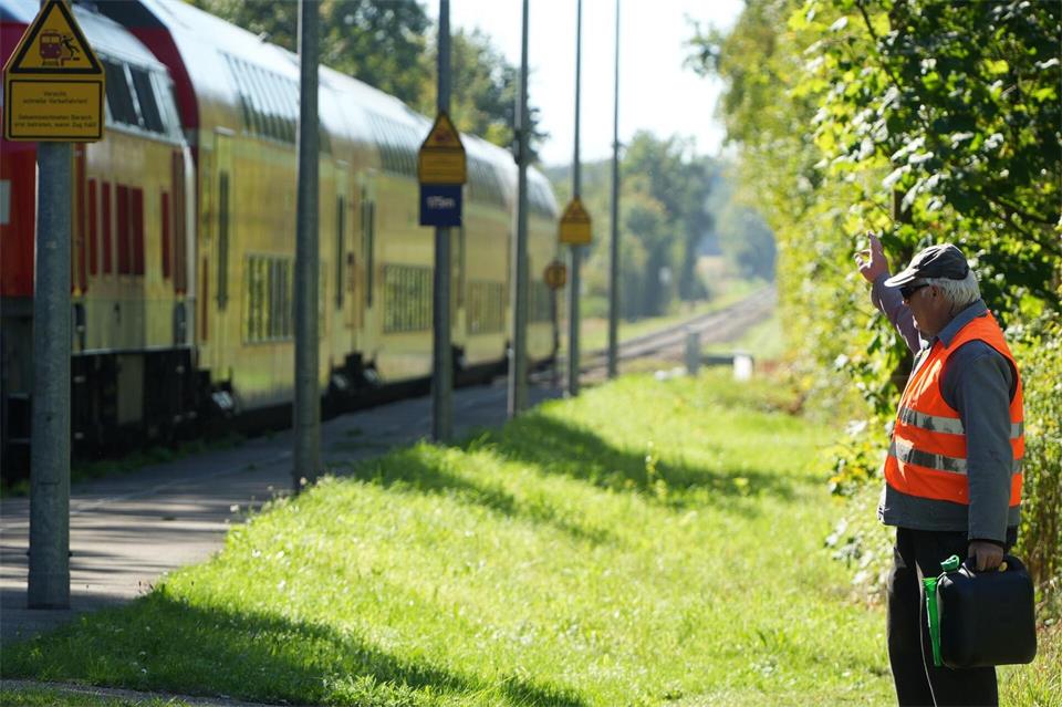 Viele kennen den engagierten Bürger: Bei seiner ehrenamtlichen Arbeit winkt der 70-Jährige den einfahrenden Zügen zu. Felix Kirberg/dpa
