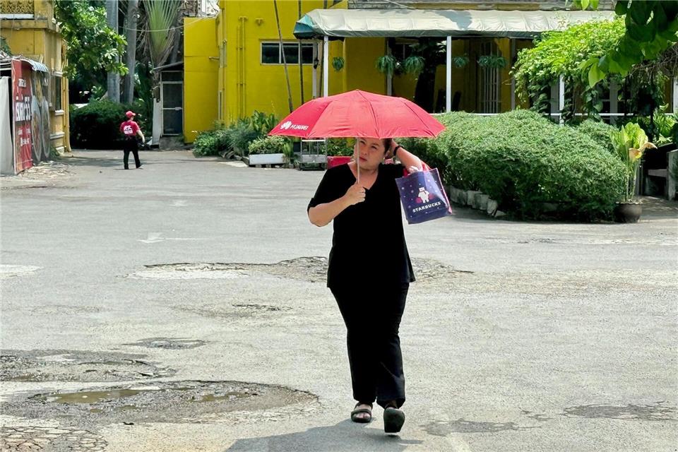 Viele schützen sich mit Schirmen vor der Sonne.Carola Frentzen/dpa