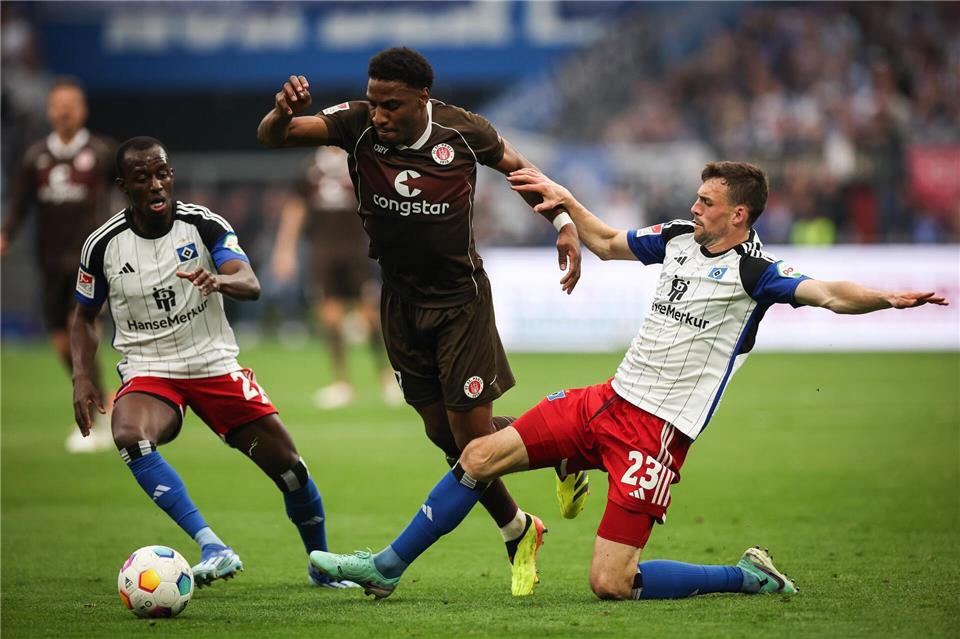 Voll dabei: St. Paulis Oladapo Afolayan (M) kämpft mit Hamburgs Jean-Luc Dompe (l) und Hamburgs Jonas Meffert um den Ball. (Archiv)Christian Charisius/dpa