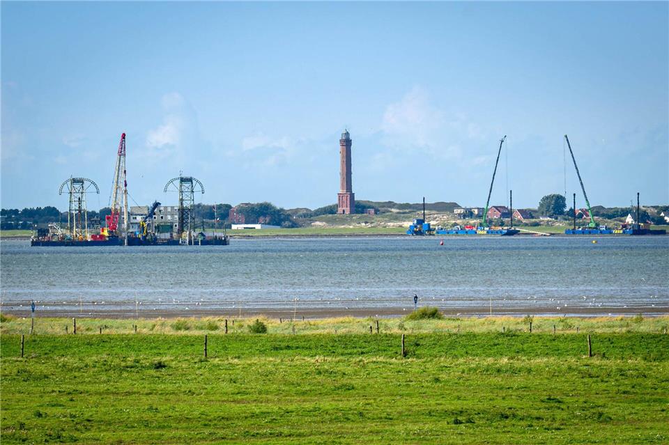 Windstrom durchs Watt leiten: Wie wird Norderney unterbohrt?  Vom Festland aus ist das Kabelverlegeschiff „Barbarossa“ im Watt vor Norderney zu sehen. Sina Schuldt/dpa