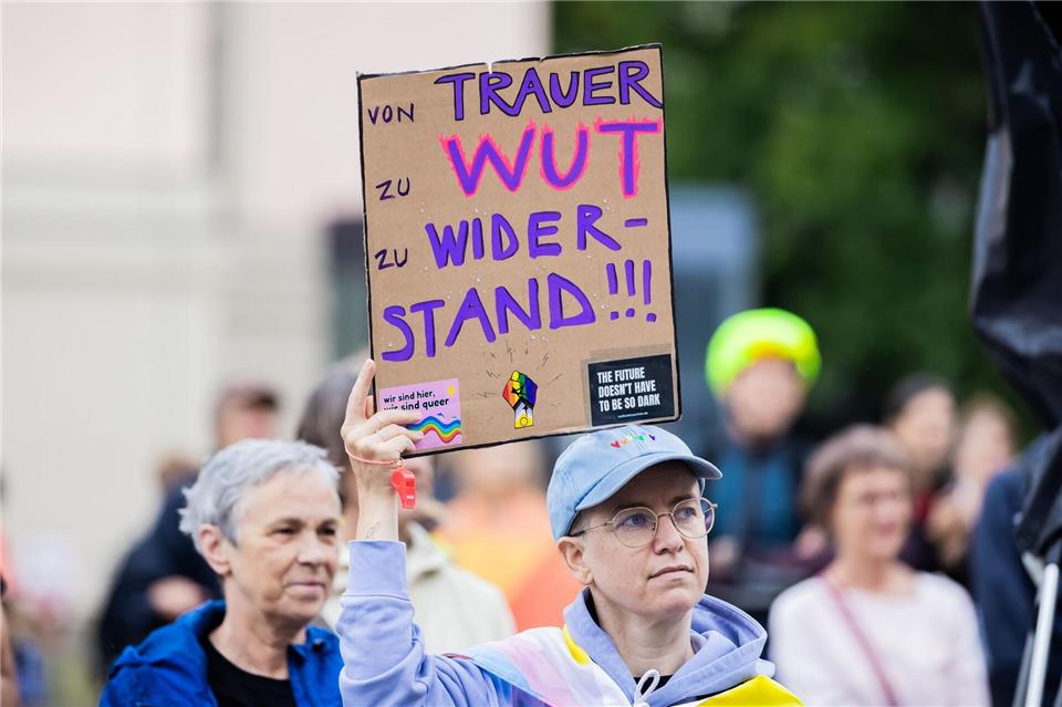 „Von Trauer zu Wut zu Widerstand“ ist auf dem selbstgeschriebenen Plakat bei einer Veranstaltung auf dem Bebelplatz zu lesen.Christoph Soeder/dpa