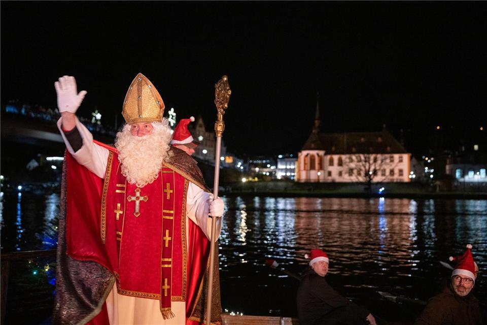 Von zahlreichen Fackelschwimmern begleitet ist der Nikolaus in Bernkastel-Kues in einem Ruderboot über die Mosel gekommen.Harald Tittel/dpa