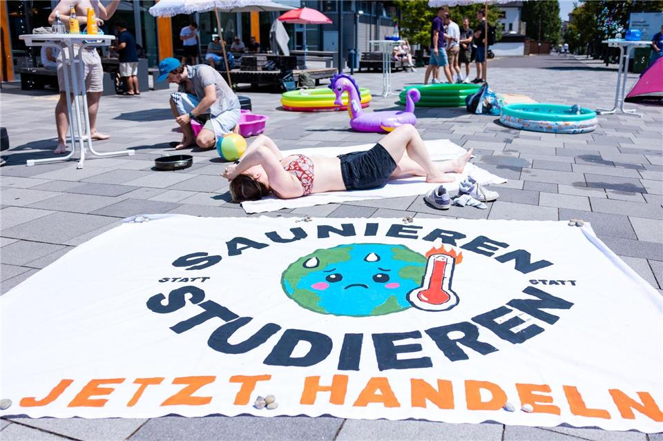 Vor Gebäude 10 am Campus Alt-Saarbrücken liegt ein Banner mit der Aufschrift „Saunieren statt Studieren – jetzt handeln“.Laszlo Pinter/dpa