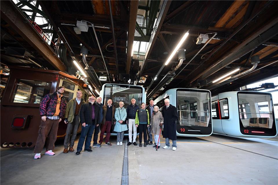Vor Schwebebahn-Fahrzeugen der ältesten und jüngsten Generation stehen in Wuppertal Nachkommen und Verwandte des Schwebebahn-Erfinders Eugen Langen.Federico Gambarini/dpa