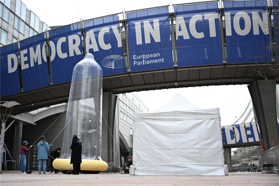 Vor dem EU-Parlament steht ein mit Luft gefülltes Kondom. Markus Lenhardt/dpa
