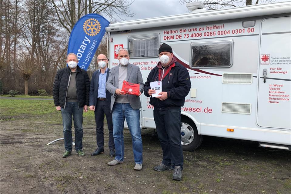 Vor dem Wohnungslosen-Mobil der Caritas in Schermbeck (von rechts): Sozialpädagoge Helge Schreiber und die Rotarier Ingo Bülow (Präsident), Stephan Proff und Thomas Abelmann.