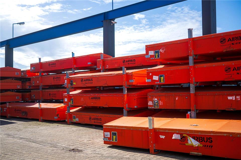 Vor der Werkhalle warten beschädigte Fahrzeugteile auf die Reparatur.Sina Schuldt/dpa