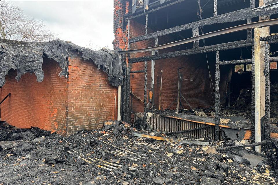 Vor der zerstörten Aula zeigt sich das Ausmaß des Brandes deutlich. (Archivbild)Kilian Genius/dpa