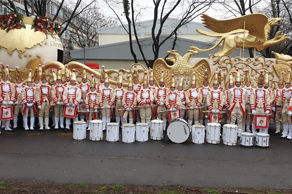 Vor einem der prunkvollen Wagen des Dreigestirns haben sich die Raesfelder Musiker für das Foto aufgestellt.