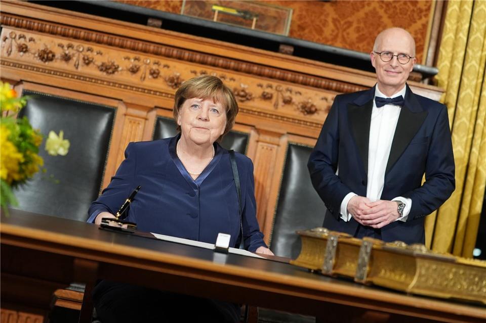 Vor ihrer Rede im Großen Festsaal des Hamburger Rathauses trägt sich Ex-Kanzlerin Angela Merkel (CDU) in das Goldene Buch der Stadt ein.Marcus Brandt/dpa