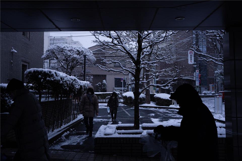 Wähler betreten ein Wahllokal in Tokio während der Unterhauswahlen in Japan.Louise Delmotte/AP/dpa