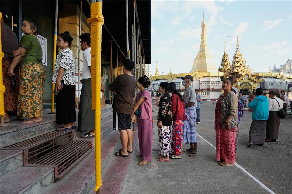 Wähler stellen sich in Yangon, Myanmar, an einem Wahllokal an.Thein Zaw/AP/dpa