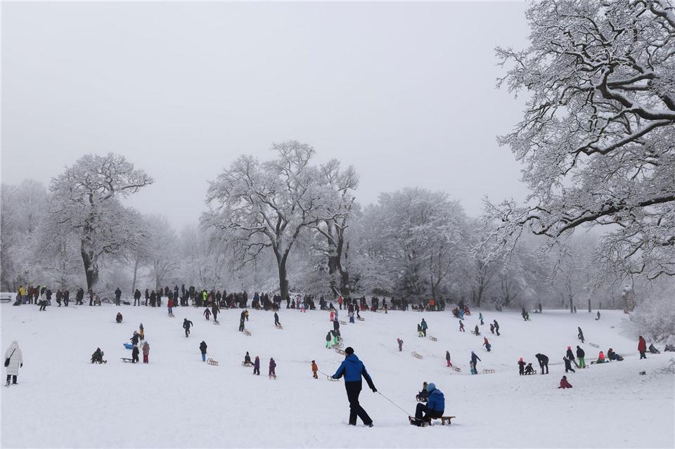Während Winterdienste und Rettungskräfte im Einsatz waren, genossen viele Menschen den Winter in Parks und Grünanlagen.Christian Charisius/dpa