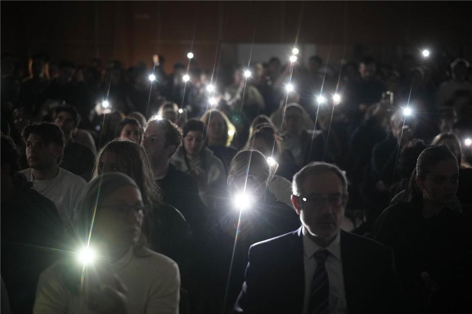 Während der Feierlichkeiten zum jüdischen Chanukka-Fest in Jerusalem leuchten Menschen mit ihren Smartphones zum Gedenken an die Toten am Bondi Beach in Sydney, Australien.Leo Correa/AP/dpa
