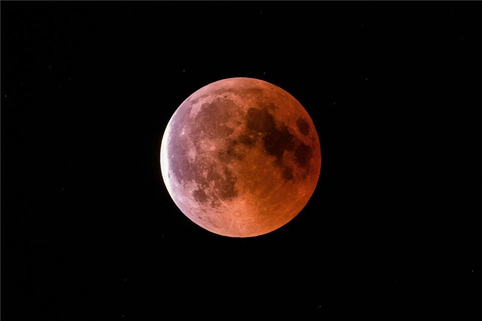 Während der Finsternis zeigt sich der Mond in rötlich-braunen Farben. (Symbolbild)Silas Stein/dpa